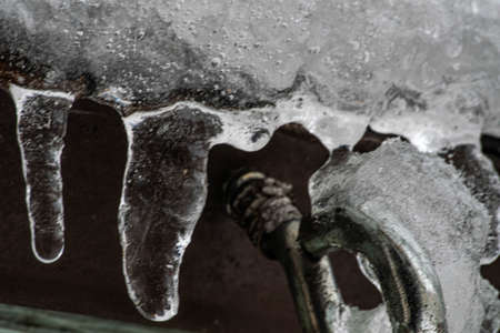 daytime close up shot of icicles on the roof of a shedの写真素材