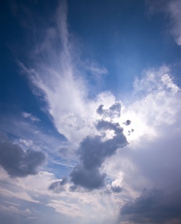 shining cloud scape with sun hidding between the cloudsの写真素材