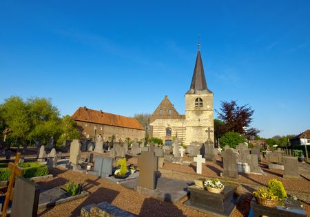 graveyard on a sunny day and blue sky with a little medieval church in the back  の写真素材