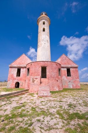 ancient lighthouse ruin on little curacao against blue cloudy skyの写真素材