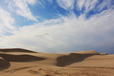 Smooth sand dunes under a sunny skyの写真素材