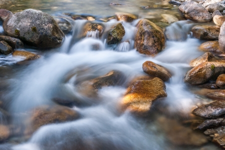 creek flowing over the rocksの写真素材