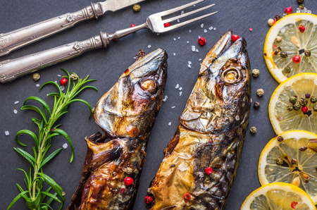Baked Whole Mackerel Fish with Spice, Lemon and Rosemary on Grey Stoneの写真素材