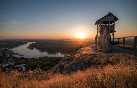 Wooden Tourist Observation Tower above a Little City of Hainburg an der Dounad with Danube River at Beautiful Sunsetの写真素材