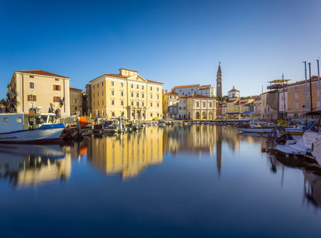 Venetian Port and The Main Square Tartini of Piran City Reflected on Water in Slovenia.の写真素材