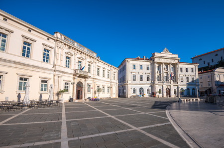 Town Hall and City Library Buildings on Tartini Square in Piran, Slovenia on a Hot Summer Day with Clear Blue Skyの写真素材