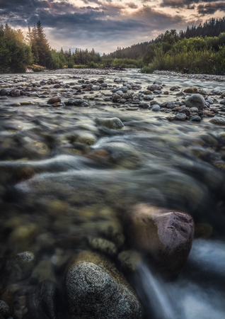 Bela River with Water Flowing over the Rocks at Sunset in Slovakiaの写真素材