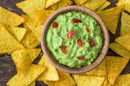 Guacamole in Wooden Bowl with Tortilla Chips. Overhead View.の写真素材