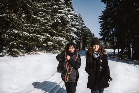 Snowroad lepeople mother and daughter walking through a winter forest in the Thuringian Forest in Germanyの写真素材