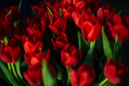 a bouquet of red roses in an iron basket
