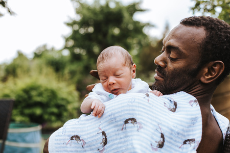 black father observing his mixed race baby boyの写真素材