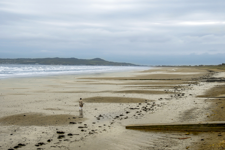 Dublin, Ireland, 25 October 2012: A Woman walking on Beach of Malahideのeditorial素材