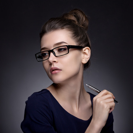 Portrait of a beautiful woman in a business style. On a gray background and beautiful makeup.の写真素材