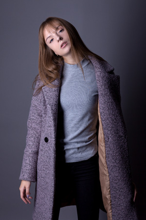 Portrait of a beautiful teenage girl in a fashionable youth image on a gray backgroundの写真素材