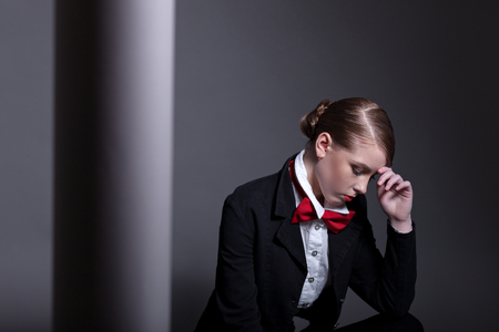 Portrait of a beautiful teen girl with a beautiful hairstyle and makeup in a simple style. Near a paper roll.の写真素材