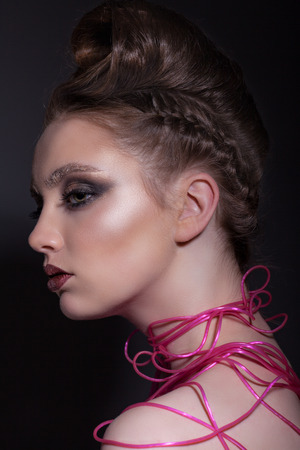 Portrait of a beautiful teen girl with a wonderful hairdo and creative make-up on a gray backgroundの写真素材