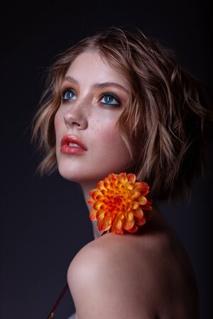Portrait of a beautiful teenager girl. With wonderful makeup and hairstyle on a dark background.の写真素材