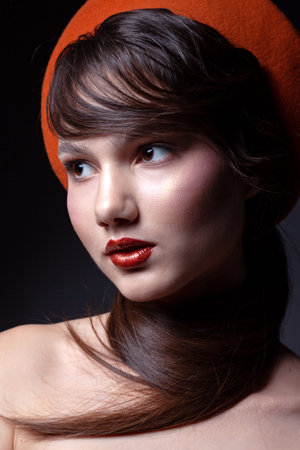 Portrait of a beautiful teenager girl. With beautiful makeup, with an orange beret on his head.