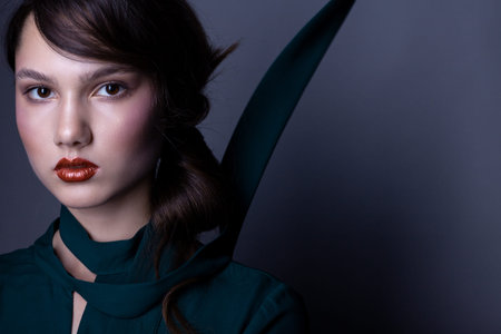 Portrait of a beautiful teenager girl. With beautiful makeup and hairstyle. In a green dress.