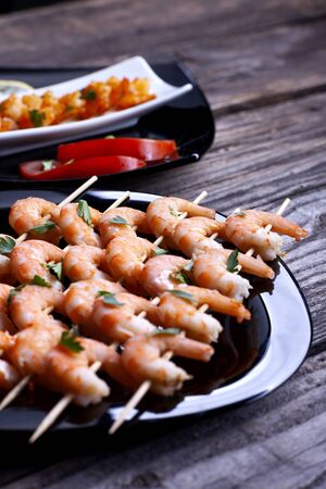 Boiled shrimp in a black plate on gray boards.の写真素材