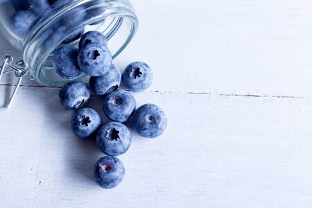 Blueberries spilled from a can on white boards. In macro shot.の写真素材