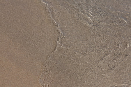 Sea water and sand, top view.