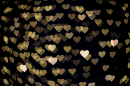 Gold heart bokeh in the dark.の写真素材