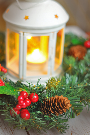 New Years wreath from a fir-tree on a white wooden background and a candle in a white candlestick. Christmas backgroundの写真素材