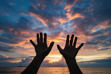 two human palms outstretched to the rays of the rising sun, faith, hopeの素材
