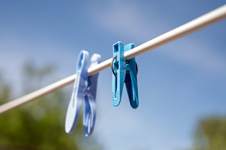clothespins on a clothesline against the blue sky in springの写真素材