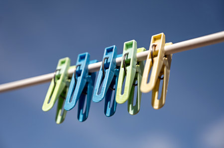 clothespins on a clothesline against the blue sky in springの写真素材