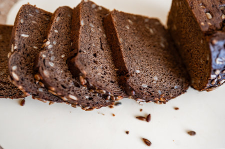 black artisan bread with seeds on a white boardの写真素材