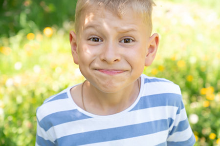 Portrait of a boy making a face in a summer park. Selective focus.の写真素材