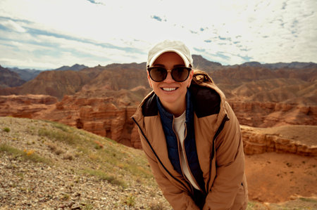 smiling tourist looking at the camera against the backdrop of beautiful orange mountains canyonsの写真素材