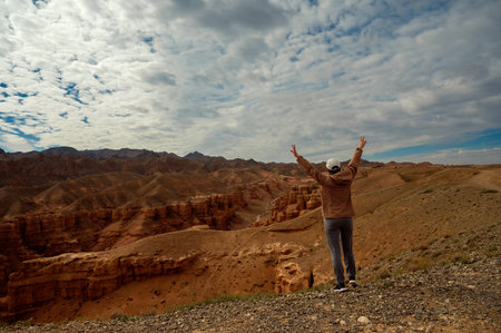 tourist raised her hands up and looks at the beautiful mountains canyons, rear viewの写真素材