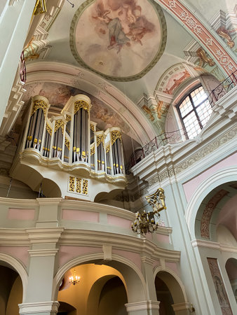 View of a beautiful golden pipe organ inside a large church, showing intricate details and majestic architectureの写真素材