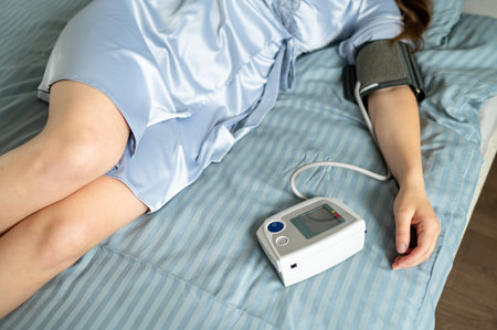 Close-up of digital blood pressure monitor and female hand during health measurement, medical technology and wellness conceptの写真素材
