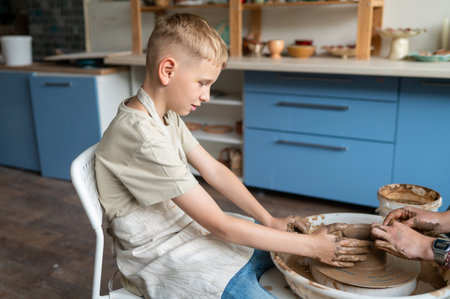 Portrait of little boy learning how to make pottery at homeの写真素材
