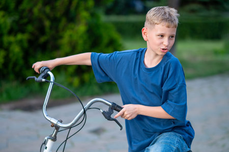 Teen blond boy cycling through a city park, enjoying outdoor activity and healthy lifestyle, concept of youth, freedom, and recreationの写真素材