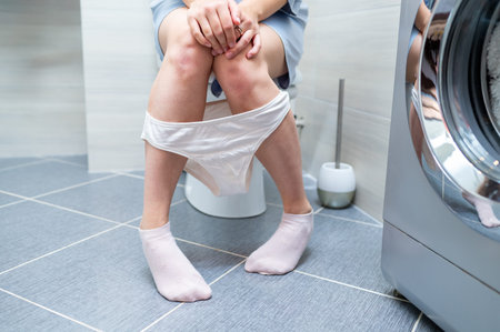 Woman sitting on toilet, facing urinary or bowel issues, concept of health problem, digestive or...