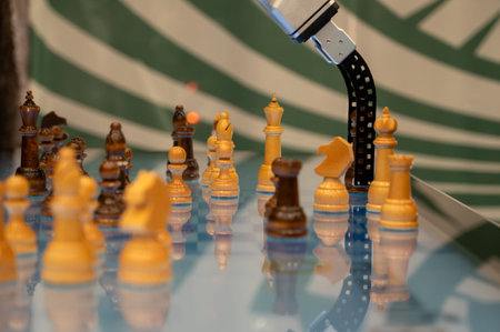 A close up shot of a high tech industrial robot manipulator moving a chess figure on a glowing blue touch display. Concept of artificial intelligence machine learning and future technology trendsの写真素材