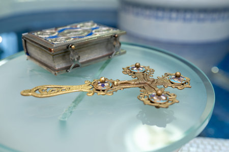 Close up of antique brass crucifix with enamel and blue velvet gospel book prepared for religious ceremony in church sacred Christian symbols of faith and spiritual traditionの写真素材