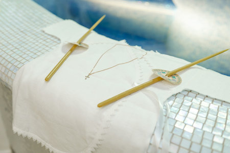 Traditional ceremonial accessories including embroidered fabric and gold pendant prepared for...