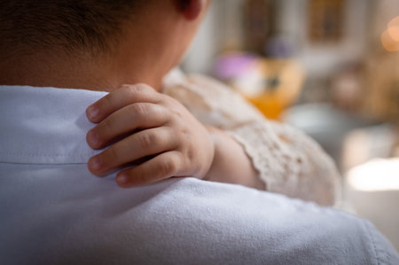 Tender moment of infant grasping parent arm conceptual shot of family connection trust childhood...