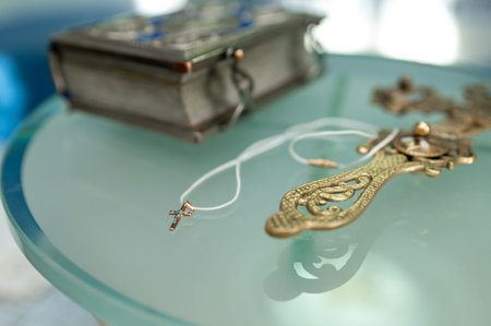 Close up of antique metal crucifix with intricate details and embossed silver bible on glass surface...