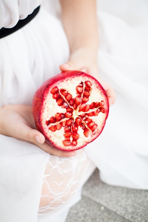 baby with a pomegranate in her hand.の写真素材
