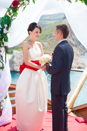 A young couple in love bride and groom with a bouquet, wedding day in summer. Enjoy a moment of happiness and love.の写真素材
