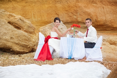 A young couple in love bride and groom posing on the beach by the sea in their wedding day in summer  Enjoy a moment of happiness and love の写真素材