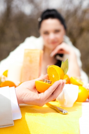 Wedding rings in orange against a background of the banquet table, creative wedding の写真素材