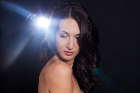 Beautiful brunette girl, a portrait in the studio on a black background の写真素材